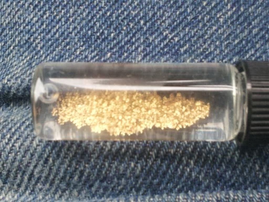 Желтый металл в колбе с водой