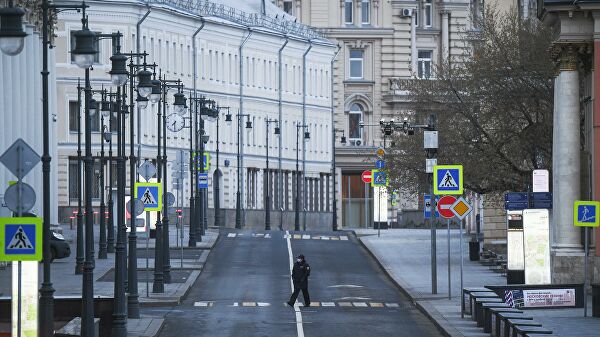 Сотрудница полиции переходит дорогу во время режима самоизоляции жителей в Москве Сотрудница полиции переходит дорогу во время режима самоизоляции жителей в Москве