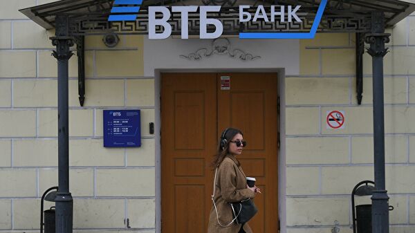 Девушка проходит мимо отделения банка ВТБ на одной из улиц в Москве Девушка проходит мимо отделения банка ВТБ на одной из улиц в Москве